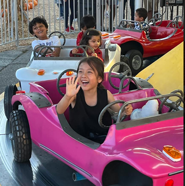 image of smiling child on carnival car ride